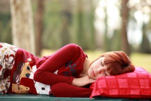 赤い枕で眠る女性
