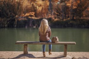 湖畔のベンチに座る女の子